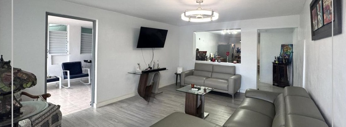 Unit 1 living room with grey sofas and wood-look floors
